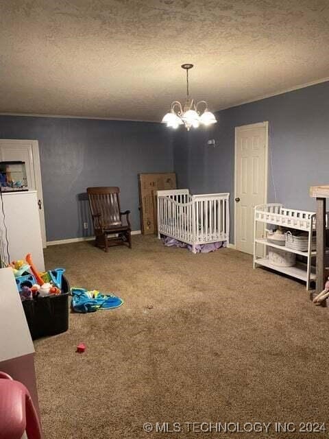 bedroom with a chandelier, carpet, and a textured ceiling