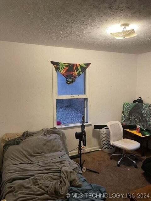 carpeted bedroom featuring a textured ceiling