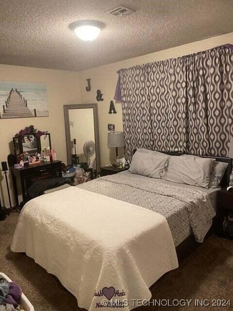 bedroom with a textured ceiling and carpet floors