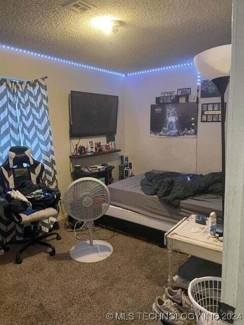 carpeted bedroom featuring a textured ceiling