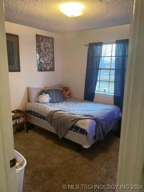 carpeted bedroom with a textured ceiling