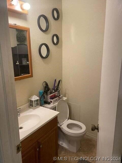 bathroom featuring toilet, vanity, and tile patterned floors