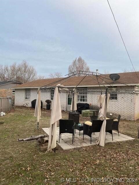 rear view of property with a lawn and a patio area