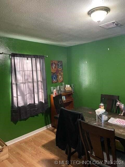 dining room featuring a textured ceiling and hardwood / wood-style flooring