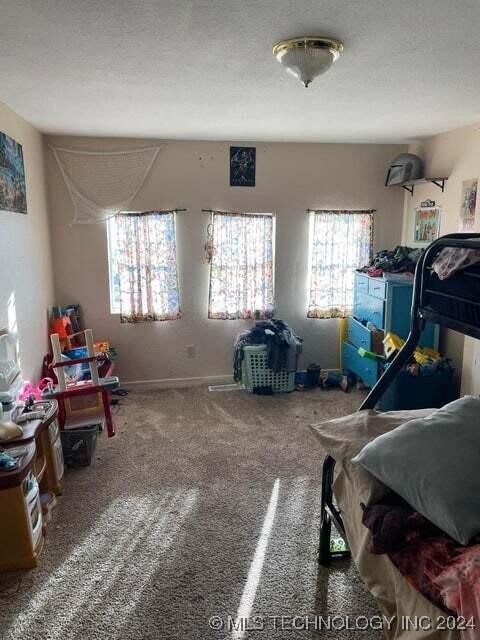 carpeted bedroom featuring a textured ceiling