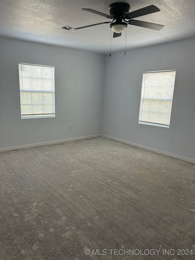 empty room featuring a textured ceiling, hardwood / wood-style flooring, and ceiling fan