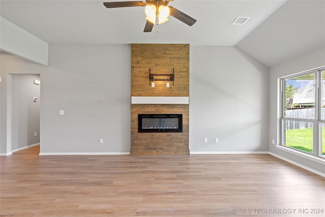 unfurnished living room with ceiling fan, a fireplace, light hardwood / wood-style floors, and vaulted ceiling