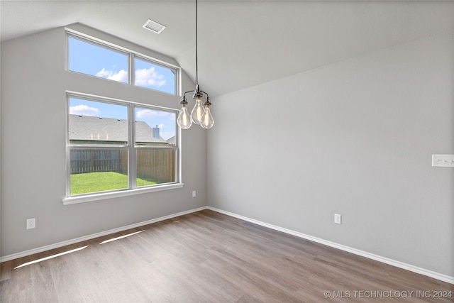 spare room featuring wood-type flooring, a wealth of natural light, and lofted ceiling