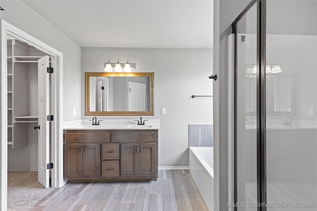 bathroom with vanity, hardwood / wood-style floors, and separate shower and tub