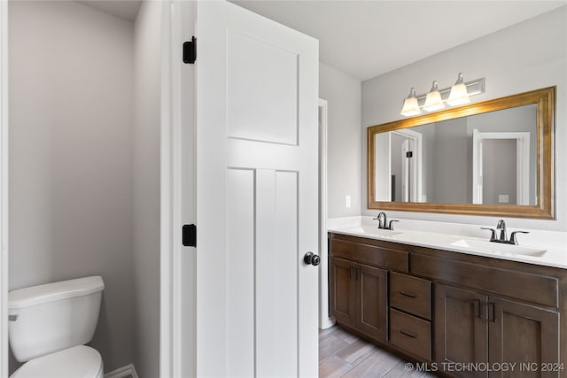 bathroom featuring vanity, toilet, and hardwood / wood-style flooring