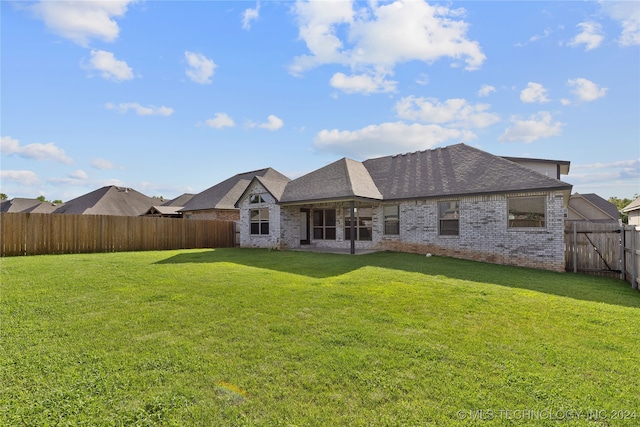 rear view of house featuring a yard