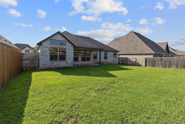 rear view of property with a yard