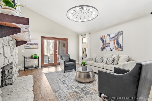 living room with french doors, lofted ceiling, hardwood / wood-style flooring, a chandelier, and a fireplace