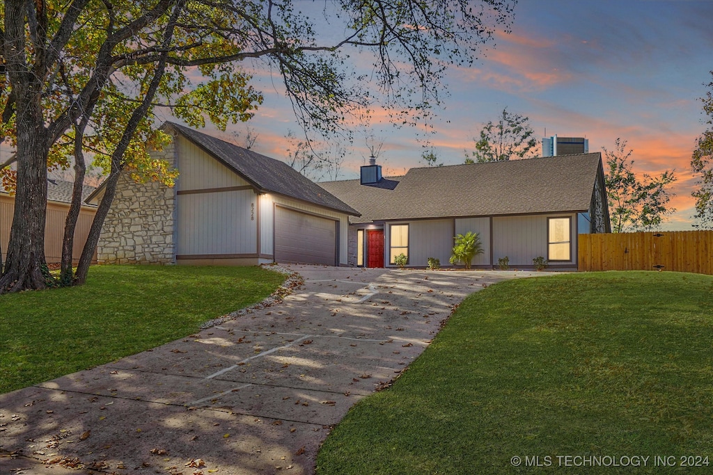 view of front of property with a garage and a yard