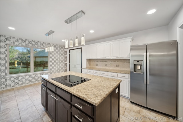 kitchen featuring stainless steel refrigerator with ice dispenser, black electric stovetop, pendant lighting, a center island, and white cabinetry