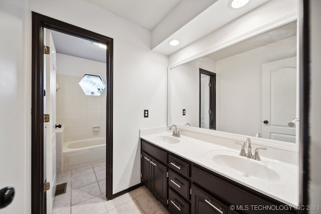 bathroom with tile patterned flooring, vanity, and tiled shower / bath