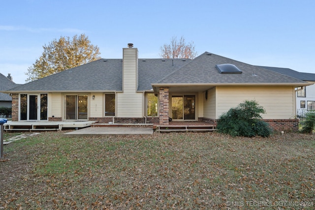 rear view of property with a yard, a patio, and a wooden deck