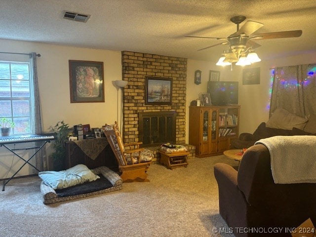 living room featuring carpet flooring, a textured ceiling, a fireplace, and ceiling fan