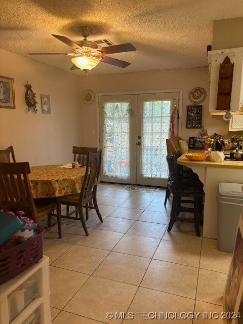 dining area with french doors, a textured ceiling, ceiling fan, and light tile patterned flooring