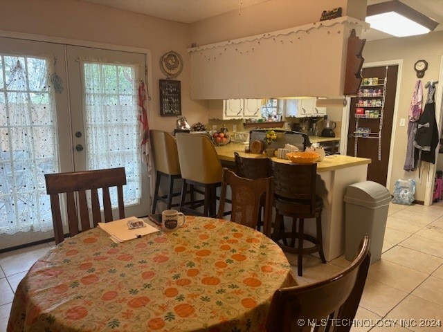 tiled dining space featuring french doors