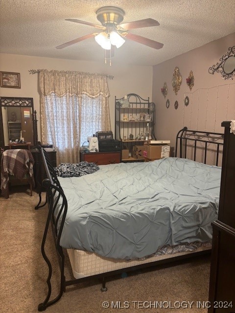 carpeted bedroom with ceiling fan and a textured ceiling