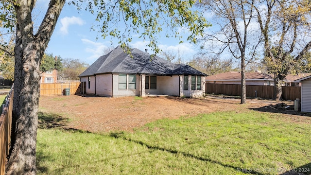 rear view of property featuring a lawn