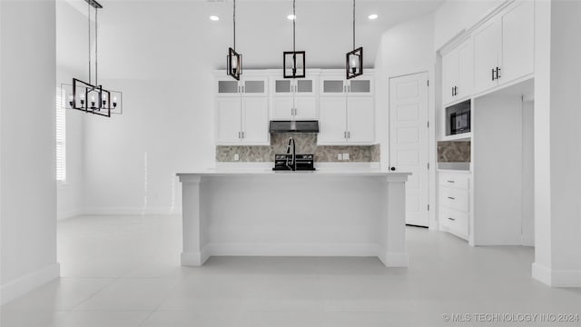 kitchen featuring stainless steel electric stove, light tile patterned floors, white cabinets, and decorative light fixtures