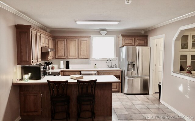 3998 E 173rd St S, Warner, OK 74469 - kitchen featuring crown molding, appliances with stainless steel finishes, light countertops, a sink, and a peninsula