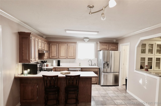 kitchen featuring a peninsula, a sink, light countertops, appliances with stainless steel finishes, and crown molding