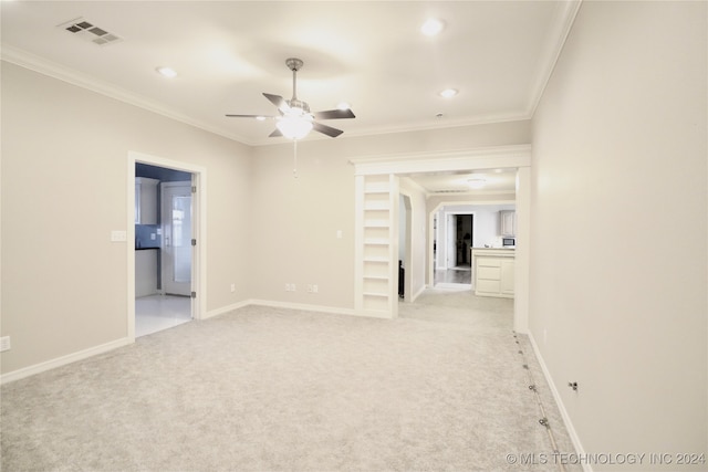 spare room with visible vents, light colored carpet, baseboards, and ornamental molding