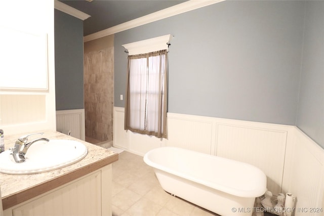 full bathroom with vanity, a freestanding tub, ornamental molding, and wainscoting