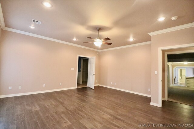 spare room featuring ornamental molding, dark wood-style floors, visible vents, and baseboards