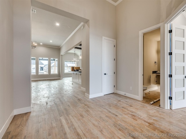 interior space featuring a chandelier, ornamental molding, and light hardwood / wood-style floors