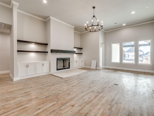 unfurnished living room with an inviting chandelier, crown molding, and light wood-type flooring