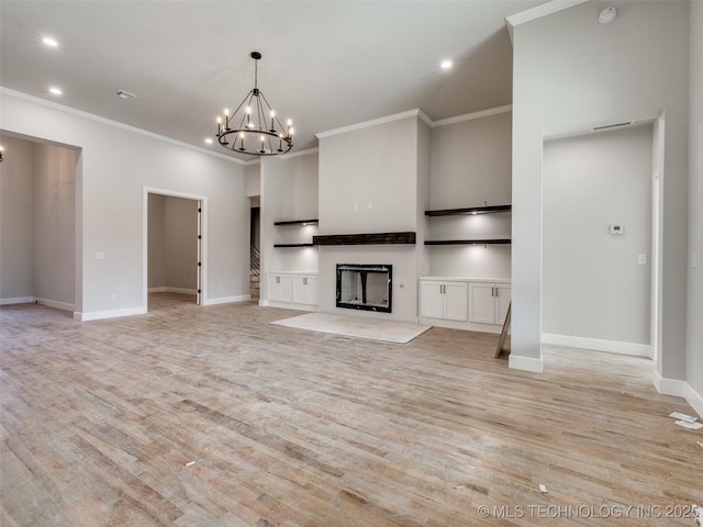 unfurnished living room with ornamental molding, a towering ceiling, light hardwood / wood-style flooring, and a notable chandelier