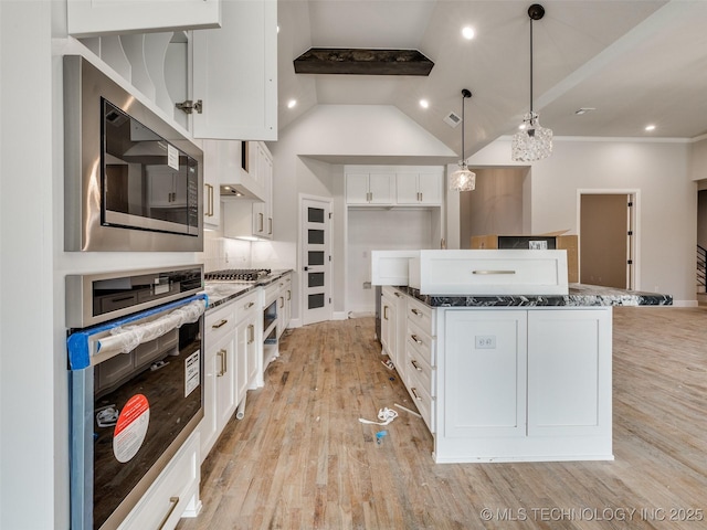 kitchen featuring decorative light fixtures, tasteful backsplash, vaulted ceiling with beams, white cabinetry, and stainless steel appliances