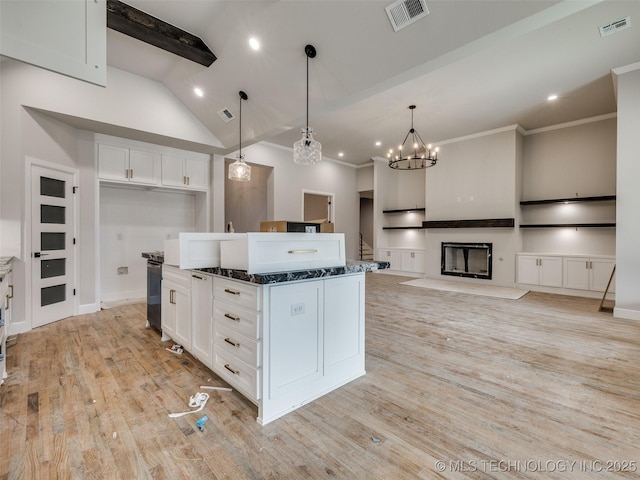 kitchen with hanging light fixtures, white cabinets, light hardwood / wood-style floors, and a kitchen island