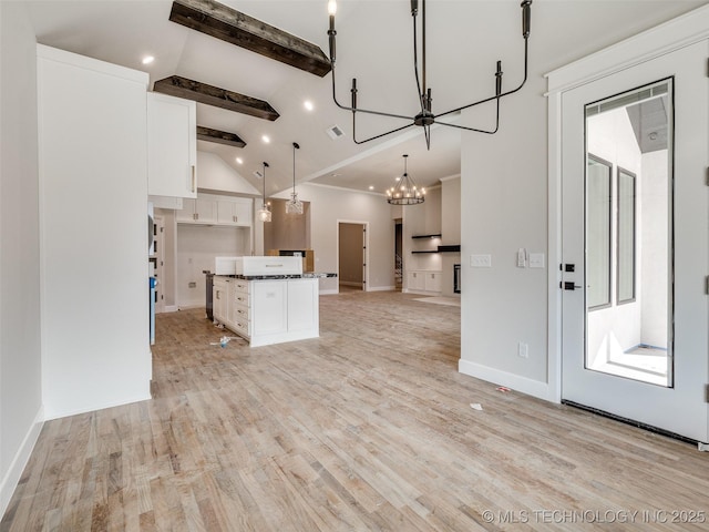 kitchen with light hardwood / wood-style floors, a kitchen island, vaulted ceiling with beams, white cabinetry, and hanging light fixtures