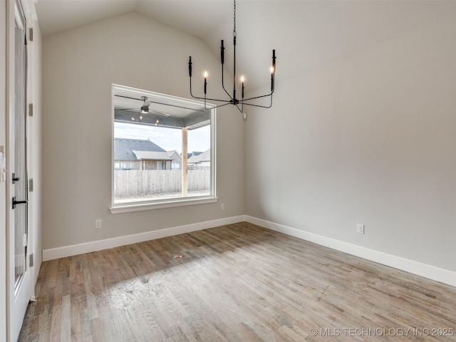 unfurnished dining area with light wood-type flooring, lofted ceiling, and a notable chandelier