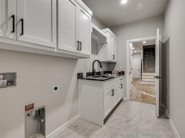 laundry room with cabinets, hookup for an electric dryer, and sink