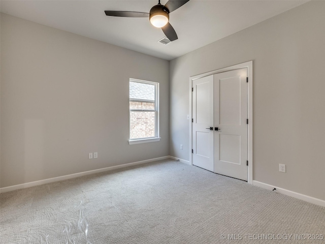 unfurnished bedroom with ceiling fan, light carpet, and a closet