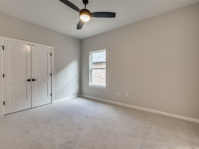 unfurnished bedroom with ceiling fan, light carpet, and a closet