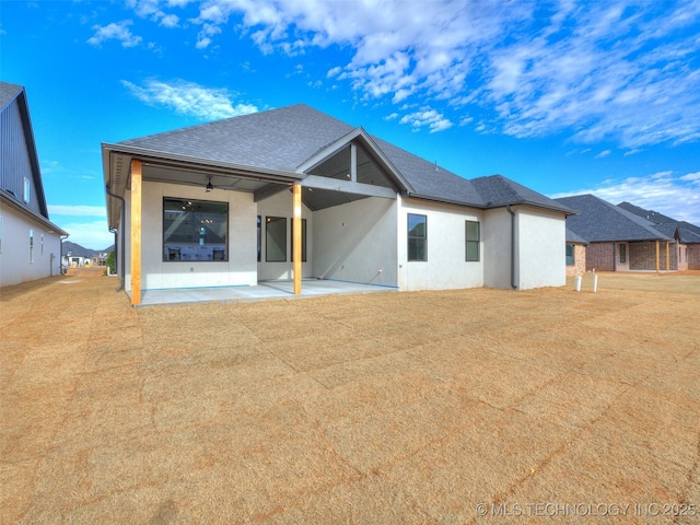 back of house featuring ceiling fan, a patio area, and a yard