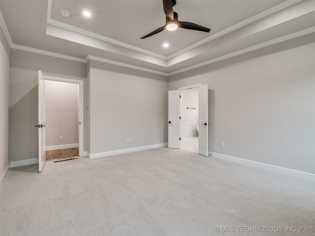 unfurnished bedroom with ornamental molding, baseboards, light colored carpet, and a raised ceiling