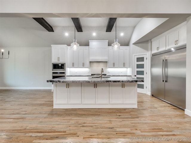 kitchen with light wood finished floors, built in appliances, beam ceiling, and tasteful backsplash
