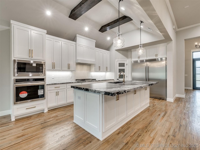 kitchen with custom exhaust hood, a sink, decorative backsplash, built in appliances, and white cabinets