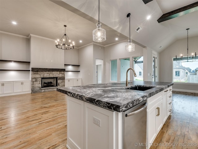 kitchen featuring visible vents, stainless steel dishwasher, a sink, light wood-type flooring, and a chandelier