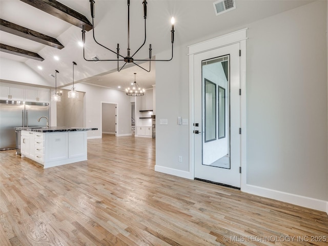 kitchen with white cabinets, open floor plan, visible vents, a chandelier, and stainless steel built in fridge
