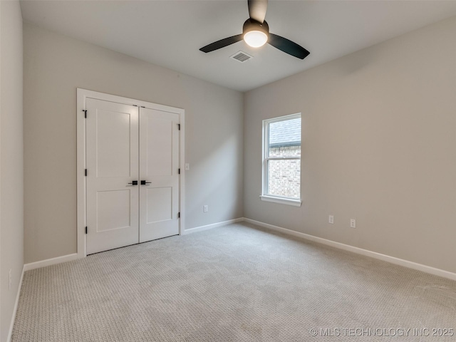 unfurnished bedroom with ceiling fan, baseboards, carpet flooring, and visible vents