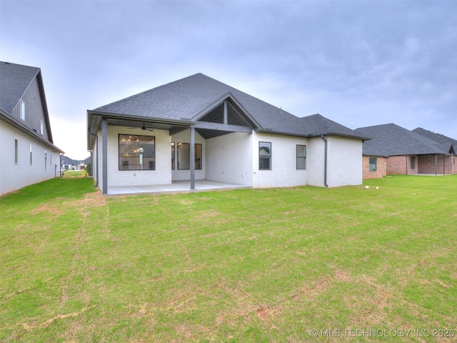 back of property with a yard, a patio area, ceiling fan, and stucco siding